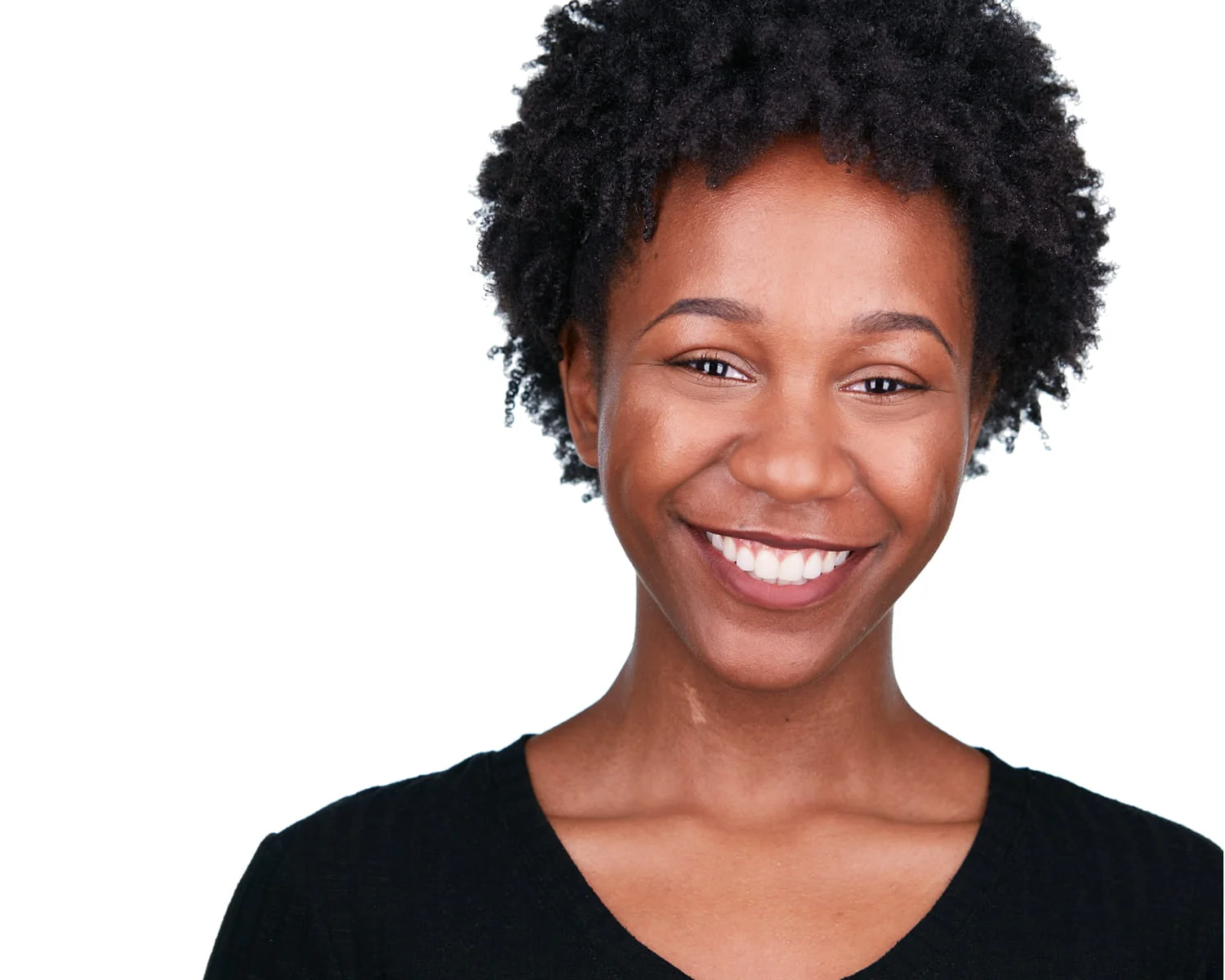 Female actor with engaging smile in black v-neck against white studio background — theatrical headshot photography
