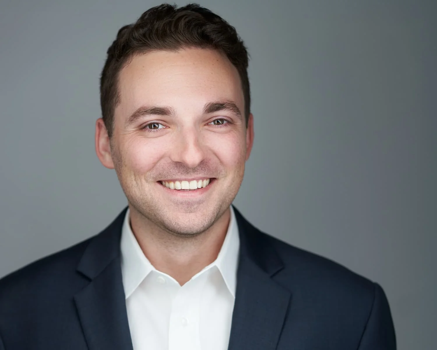 Professional headshot showing clean solid color clothing that keeps focus on the subject's expression and face