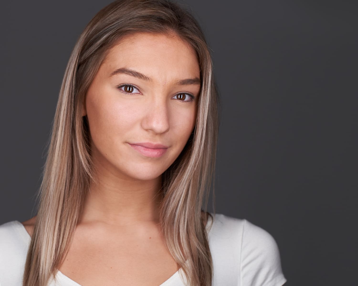 Professional modeling headshot featuring natural makeup and white top