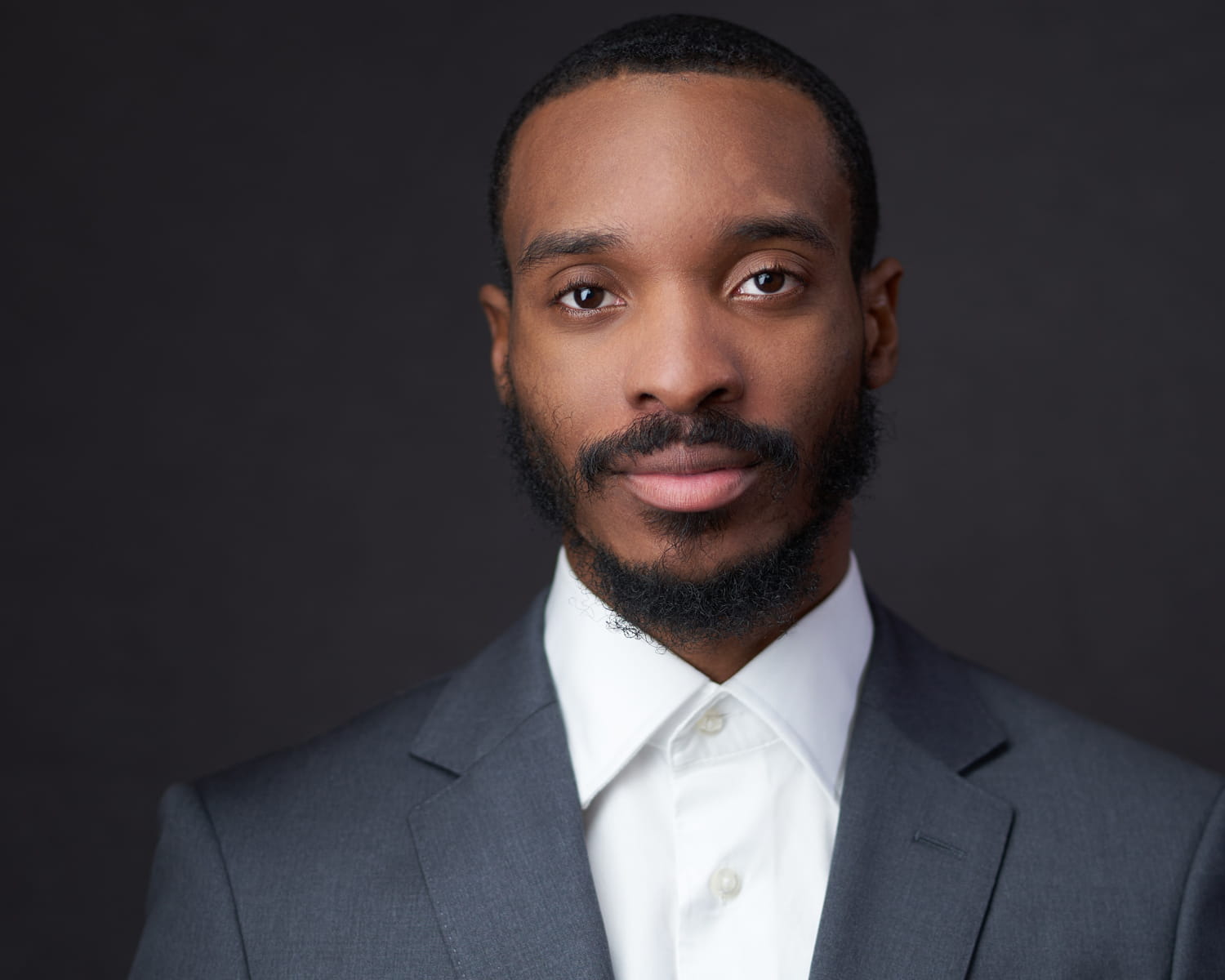 Business professional in charcoal suit and white collar shirt - modern corporate portrait